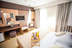 a hotel room with a bed and a desk and a television at Hotel Herceg in Međugorje