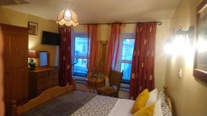 een slaapkamer met een bed, een stoel en ramen bij Vaughans Pub/Accommodation in Clifden