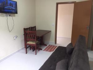 a living room with a couch and a table at Loft Juquehy in São Sebastião