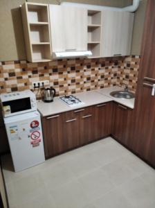 una piccola cucina con piano cottura e lavandino di Квартира в ЖК Атриум a Irpin'