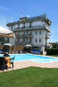 um hotel com piscina em frente a um edifício em Albergo Al Cacciatore em Desenzano del Garda