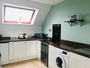 a kitchen with a washer and dryer and a window at Skerry View - Overlooking the Moray Firth - close to Beaches, Harbour, Shops and Restaurants in Lossiemouth
