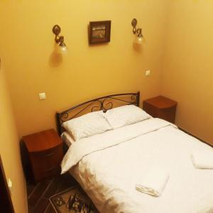 ein Schlafzimmer mit einem weißen Bett und zwei Nachttischen in der Unterkunft Sofiivs'ka Street, 1,, in Kiew