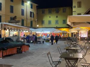 un mercado al aire libre con mesas y sillas por la noche en Gaia's Apartment, en Pistoia