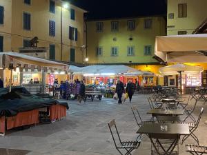 an outdoor market with tables and chairs at night at Gaia's Apartment in Pistoia