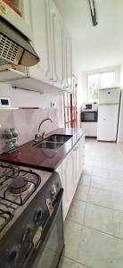 a kitchen with a stove and a sink in it at Amplios Departamentos en Corrientes in Corrientes