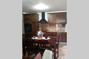 a kitchen with a dining room table with chairs and a kitchen at Casa Rural A Eira Vella in Padrón