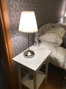 a table with a lamp on it next to a bed at Forest View - Castlewellan, County Down in Belfast