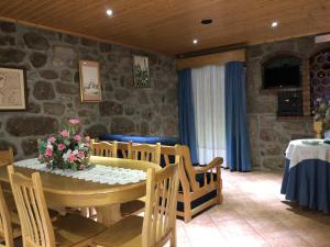 uma sala de jantar com uma mesa com flores em Casa Pelourinho em Gouveia