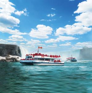 a group of people on a boat in front of a waterfall at Country Inn & Suites by Radisson, Niagara Falls, ON in Niagara Falls