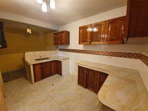 a kitchen with wooden cabinets and a counter top at HOSTAL EL TORNILLO 3 in Lima