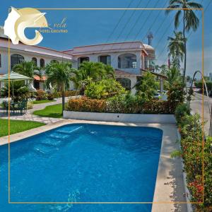 a house with a blue pool in front of it at Hotel Pez Vela in Manzanillo