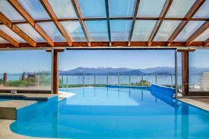 a swimming pool with a view of the water at Sol del Nahuel - Hotel & Spa in San Carlos de Bariloche