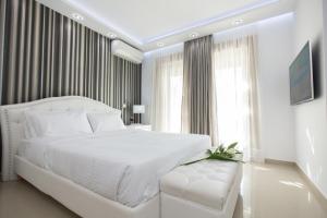 a white bedroom with a large white bed and a couch at Larimar Luxury Sea View Villa in Kissamos