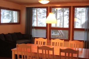 uma sala de estar com uma mesa e cadeiras e um sofá em Camping Merihelmi em Myllykangas