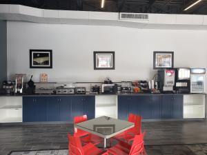 cocina con mesa y sillas rojas en una habitación en Post Time Inn, en Carlsbad