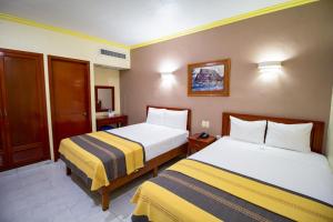 a hotel room with two beds in a room at Hotel El Español Centro Historico in Mérida