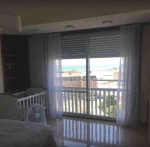 ein Schlafzimmer mit einem Fenster mit Blick auf einen Balkon in der Unterkunft ArielMardel in Mar del Plata