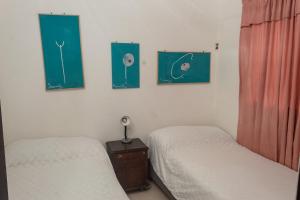 a bedroom with two beds and two paintings on the wall at Apartamento amoblado in Quibdó