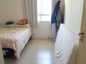 een kleine slaapkamer met een bed en een raam bij 1/4 MOBILIADO EM FRENTE À PRAIA, EM SALVADOR BAHIA in Salvador