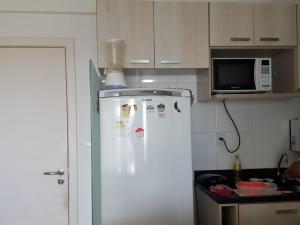 een witte koelkast in een keuken met een magnetron bij 1/4 MOBILIADO EM FRENTE À PRAIA, EM SALVADOR BAHIA in Salvador