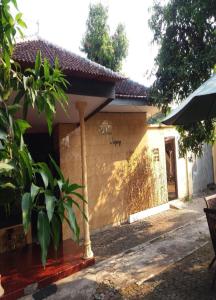 una casa con un pilar delante de ella en Ndalem Diajeng, en Yogyakarta