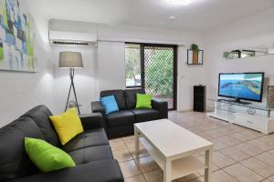 a living room with a couch and a tv at Allure Apartments - Central in Mildura