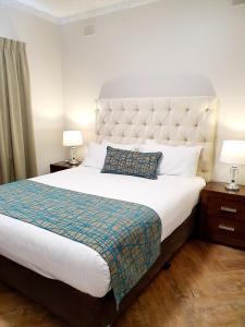
a hotel room with a white bed and white comforter at Largs Pier Hotel in Adelaide
