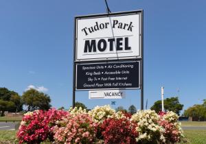 - un panneau indiquant le parc du tudor avec des fleurs dans l'établissement Tudor Park Motel, à Gisborne