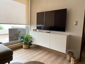 a living room with a flat screen tv on a wall at Terrazas de Cochoa in Viña del Mar