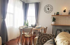 a living room with a table and chairs and a clock at Quick Stroll To The City in Geraldton