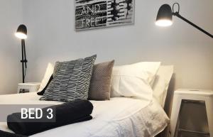 - un lit avec des oreillers et une pancarte dans l'établissement Quick Stroll To The City, à Geraldton