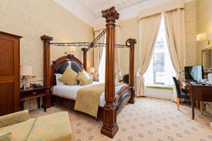 Dormitorio con cama, escritorio y TV en Castle Hotel, en Dublín