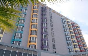 a tall building with many windows and a palm tree at Hotel Grand Continental Kuala Terengganu in Kuala Terengganu
