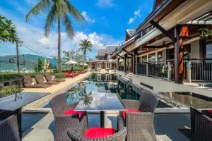 une image d'un complexe avec une piscine et des chaises dans l'établissement Baan Yin Dee Boutique Resort Phuket - SHA Plus, à Patong Beach