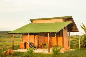 una pequeña casa con techo verde en un campo en Raizando Ecologia Humana en Alto Paraíso de Goiás