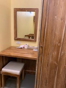 a small bathroom with a mirror and a wooden table at Thiwson Beach Resort - SHA Extra Plus in Ko Yao Yai