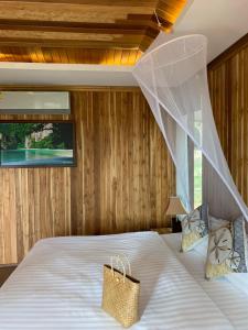 a bedroom with a bed with a mosquito net at Thiwson Beach Resort - SHA Extra Plus in Ko Yao Yai