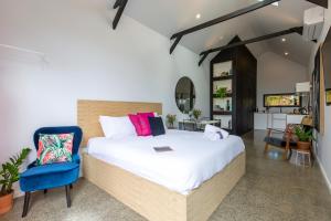 a bedroom with a large bed and a blue chair at Nowra Studio Barn in Nowra