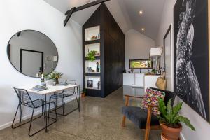 a living room with a mirror and a table and chairs at Nowra Studio Barn in Nowra