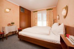 ein Schlafzimmer mit einem Bett und einem Tisch und einem Fenster in der Unterkunft St. Oswalderhof in Pörtschach am Wörthersee