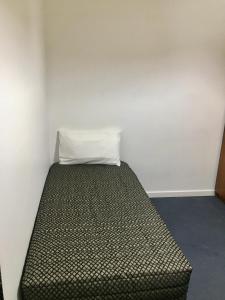 a bed in a room with a pillow on it at The Sands Motel Adelaide in Adelaide