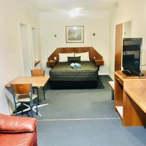 um quarto de hotel com uma cama e uma mesa em The Sands Motel Adelaide em Adelaide