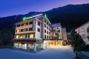 a hotel building with a sign on it at night at Holiday Inn Express Jiuzhaigou, an IHG Hotel in Jiuzhaigou