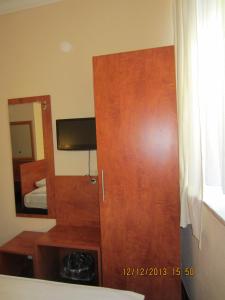 een slaapkamer met een houten deur en een spiegel bij Altstadt Hotel Rheinblick in Düsseldorf