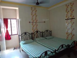 um quarto com uma cama com lençóis verdes e uma janela em New Regency em Chennai