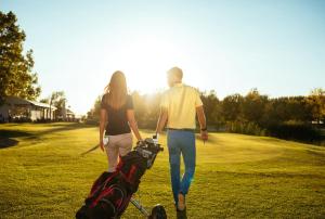 un homme et une femme se promenant sur un parcours de golf dans l'établissement Quick Stroll To The City, à Geraldton