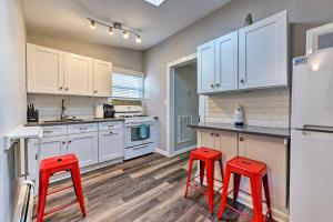 a kitchen with white cabinets and red stools at Gulf Coast Cottage - Walk to Beach and Boardwalk! in Point Pleasant Beach