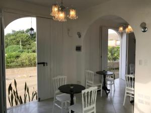 a dining room with white chairs and tables and a large window at El Nido Boutique B&B in Puerto López