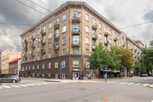 een groot bakstenen gebouw op de hoek van een straat bij Dandelion Apartments Stabu in Rīga